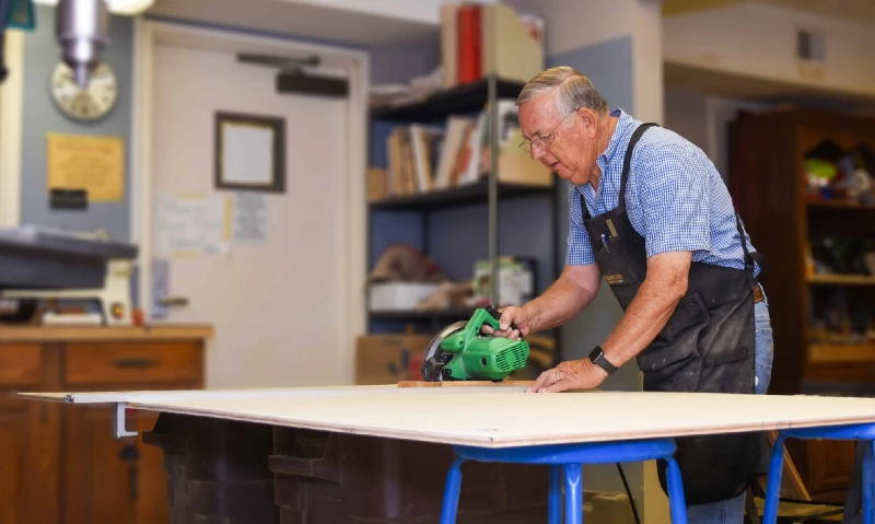 A Brewster Place resident uses a skill saw very carefully.