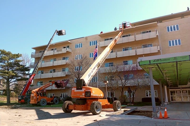 Construction equipment reaching to the top of the Redwood.